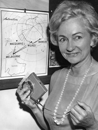 Portrait of Norma Ferris holdng an audio tape next to a map of Antarctica