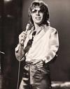 Three-quarter image of singer Stevie Wright holding a microphone and standing on a stage.