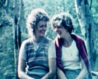 Two women sitting next to each other smiling