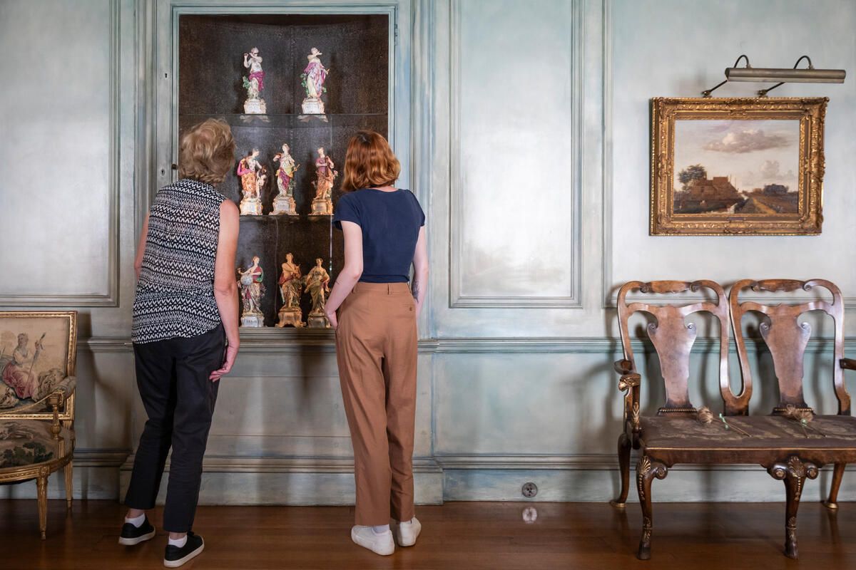 Visitors admiring the display of Apollo and the Nine Muses, Chelsea Porcelain Factory (1744-1769) at Upton House, Warwickshire
