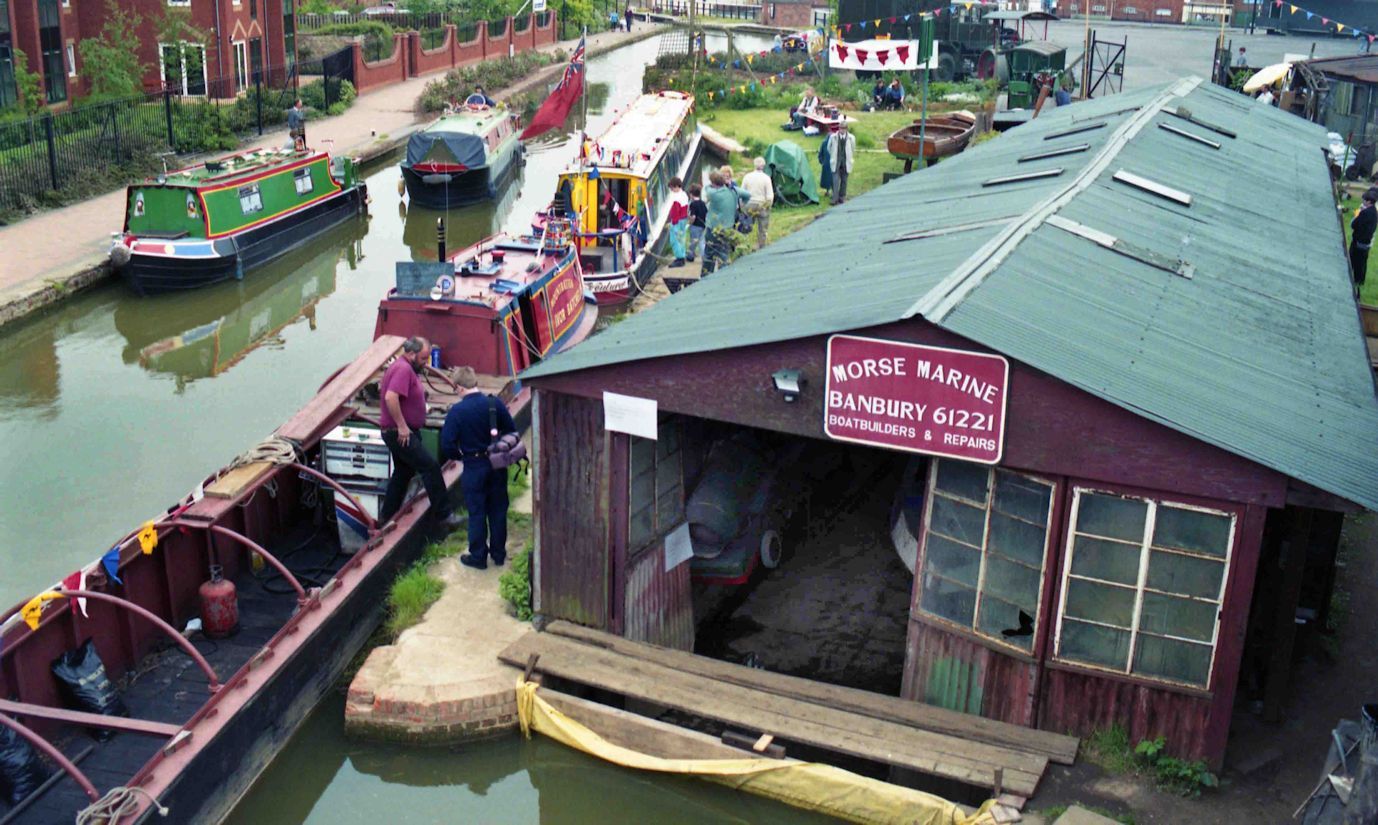 A traditional narrowboat moored at the historic brick workshops of Tooley's Boatyard along the Oxford Canal in Banbury.