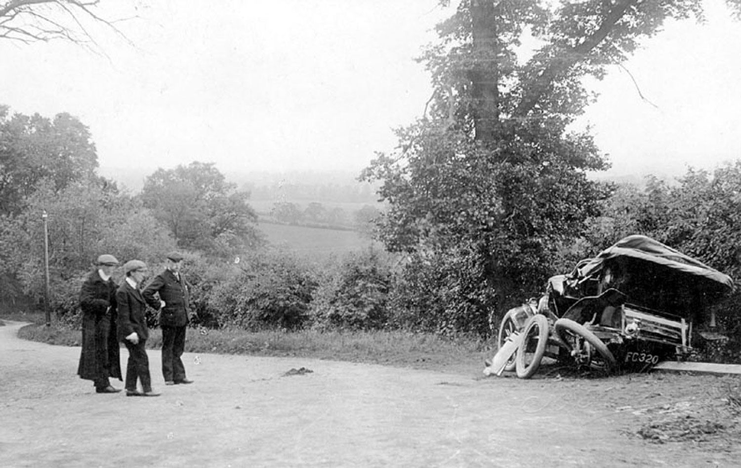 Scene of a motor car accident on Sunrising Hill, Edgehill. June 10th 1907. Three men looking at wrecked car.