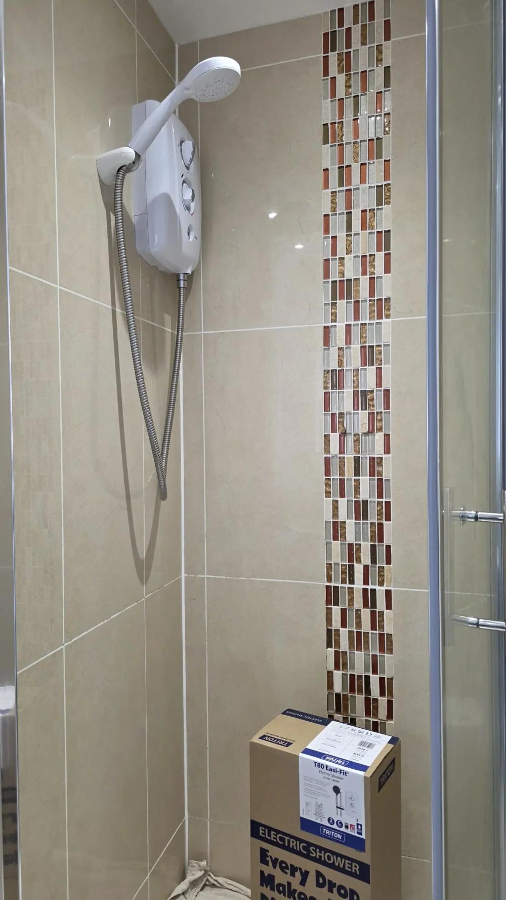 Shower enclosure with the electric shower and its box on the tray