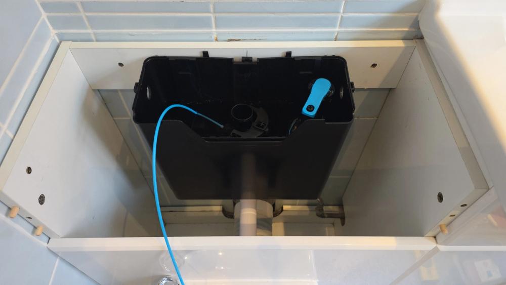 New concealed cistern with its blue water supply hose connected