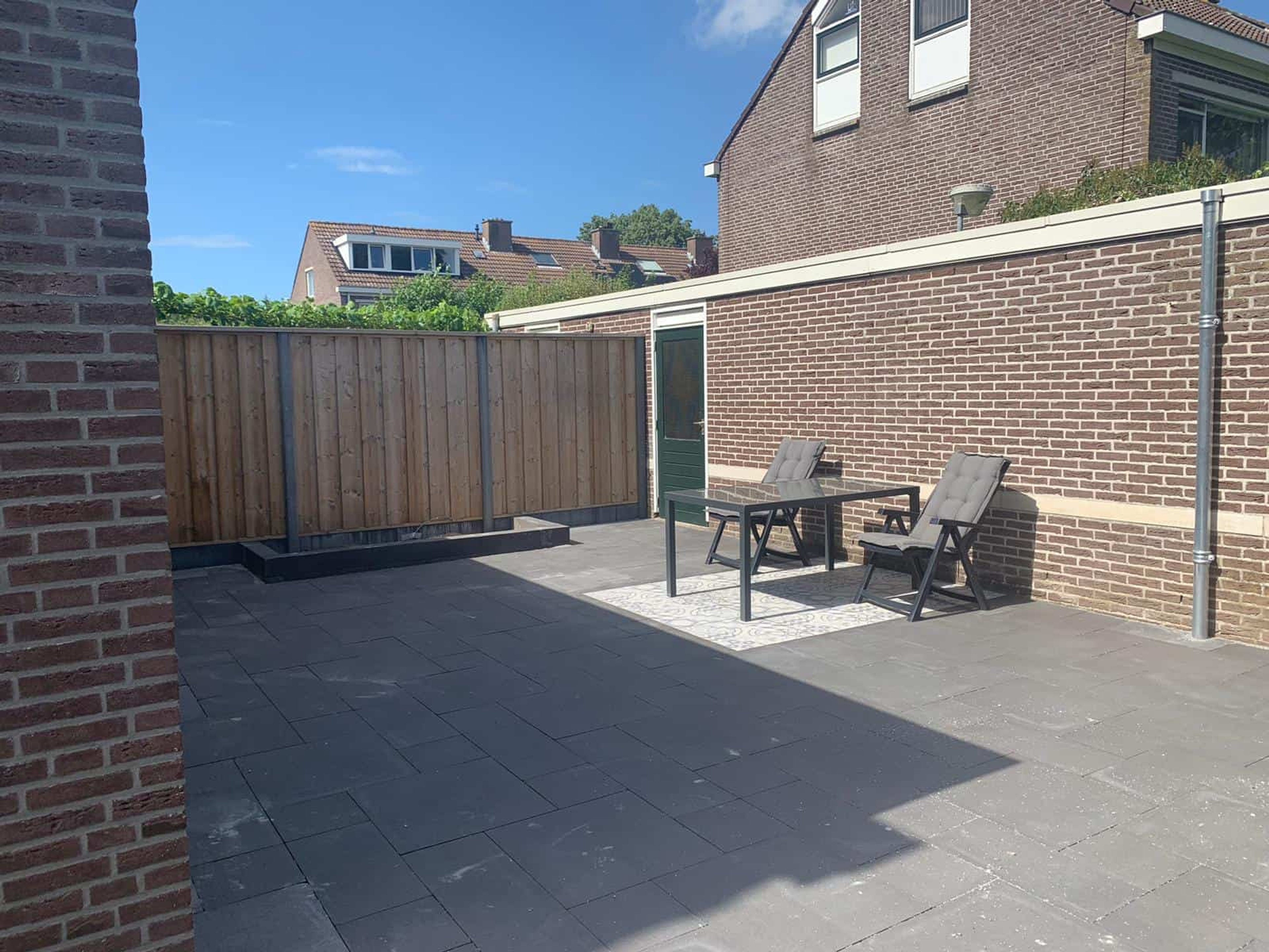 Strakke achtertuin met wildverband bestrating en Geoceramica terras