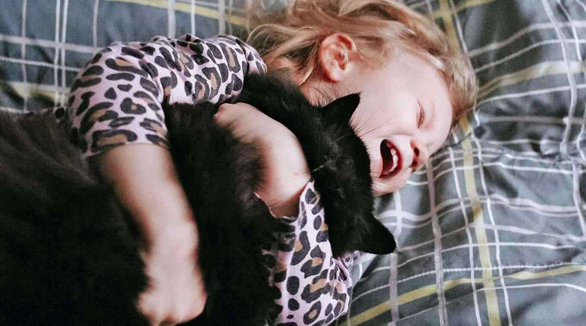 child hugging cat