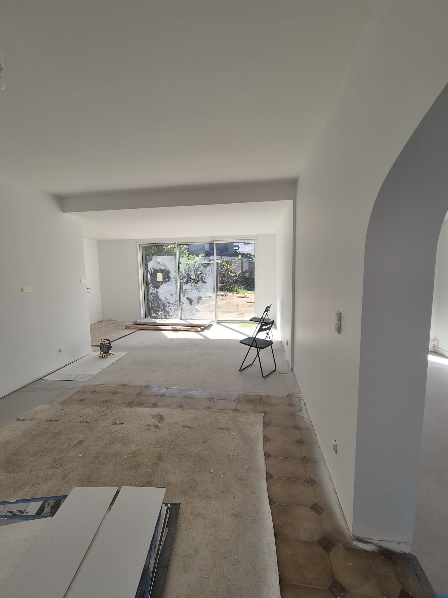 Grande pièce en cours de finition, plafond courbe et baie vitrée