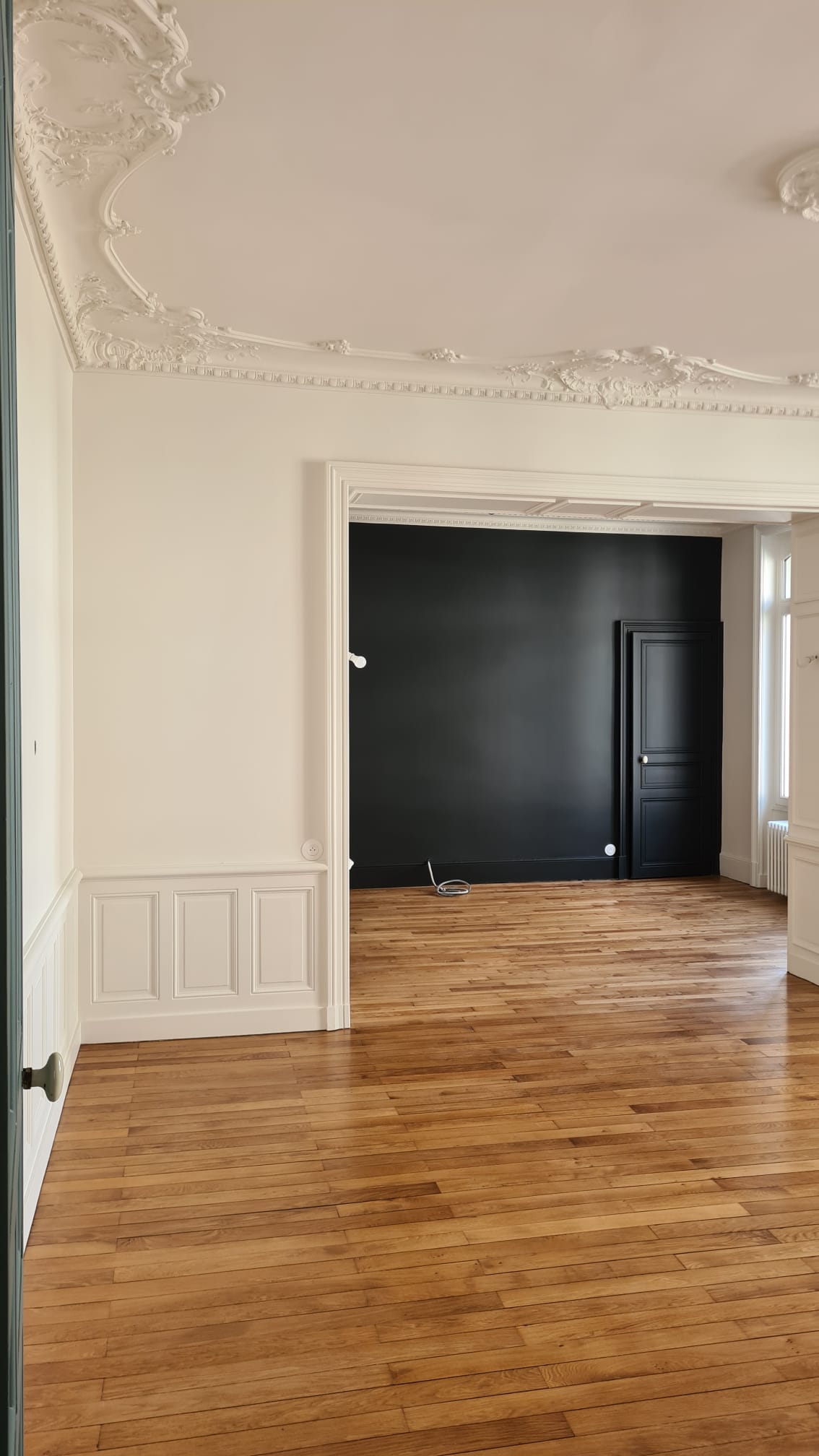 Pièce de réception aux corniches blanches et portes laquées noir mat