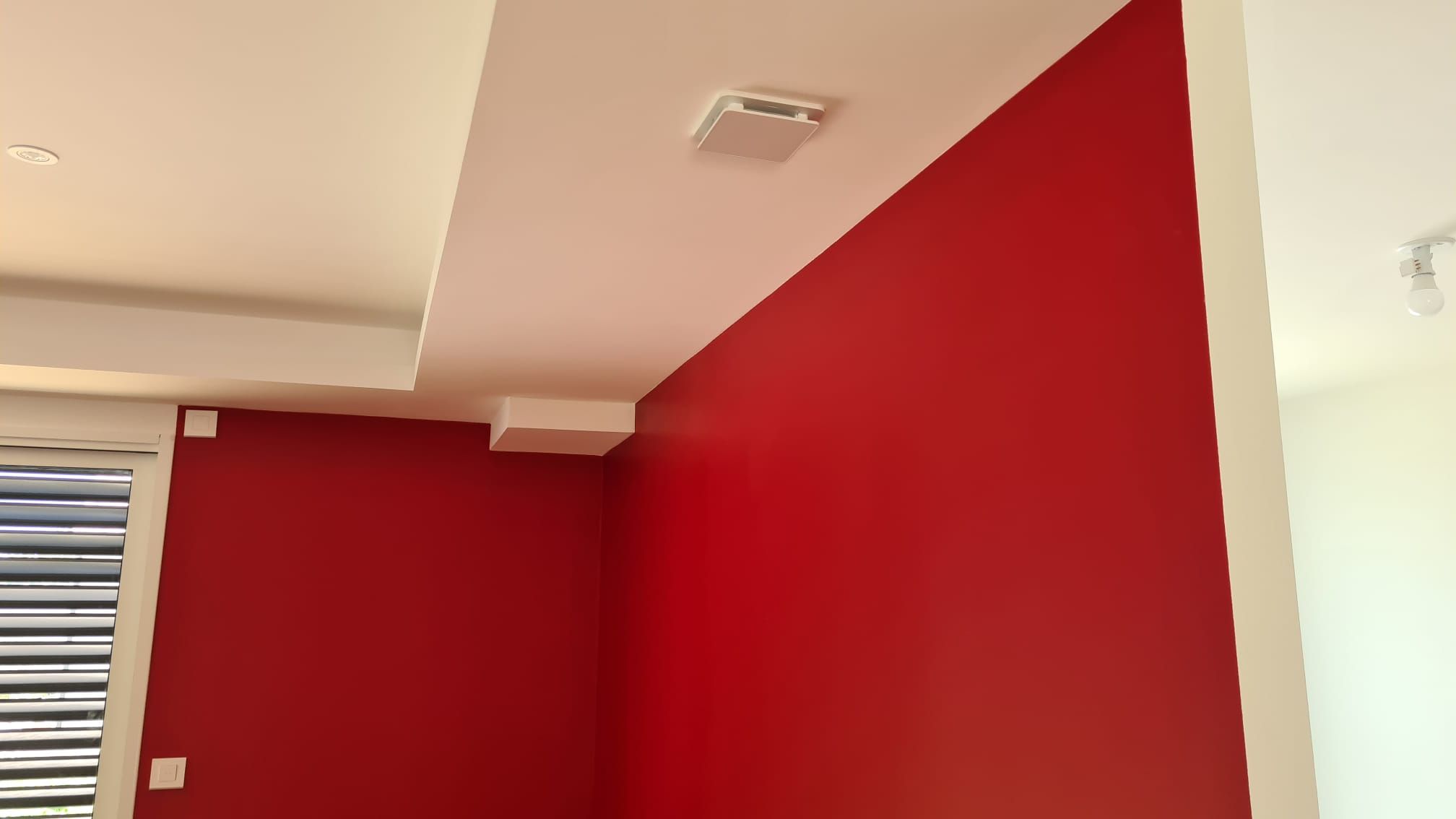 Angle de séjour, mur rouge et retour de plafond blanc