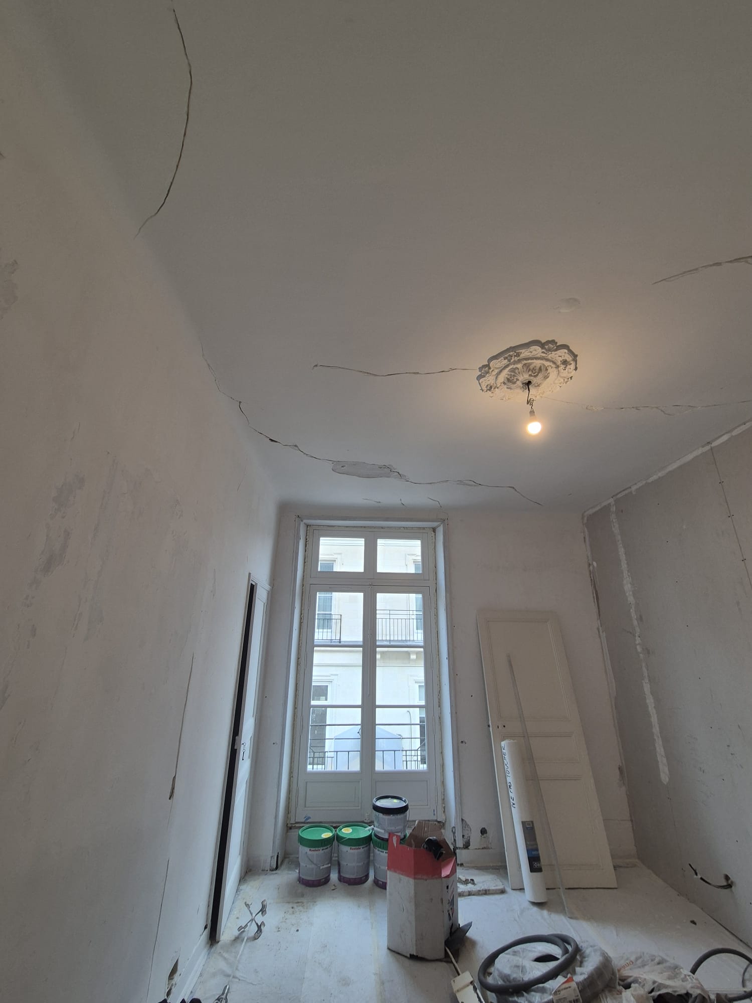 Plafond fissuré avec rosace de plâtre, avant travaux