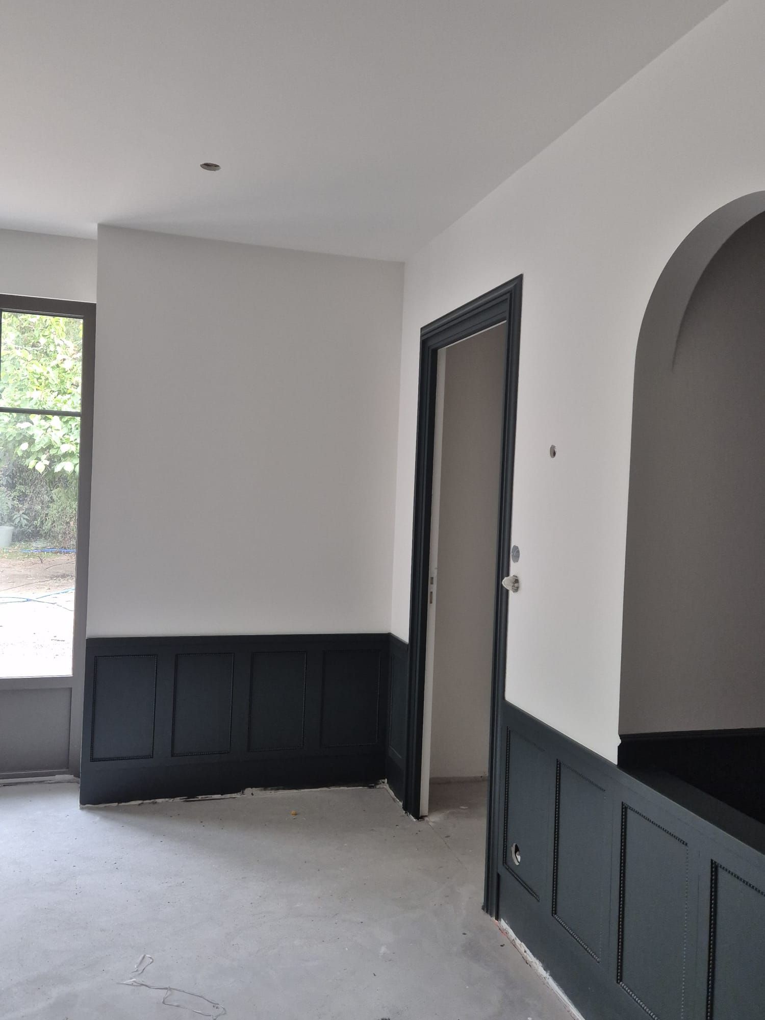 Chambre aux murs clairs, soubassement anthracite et porte laquée