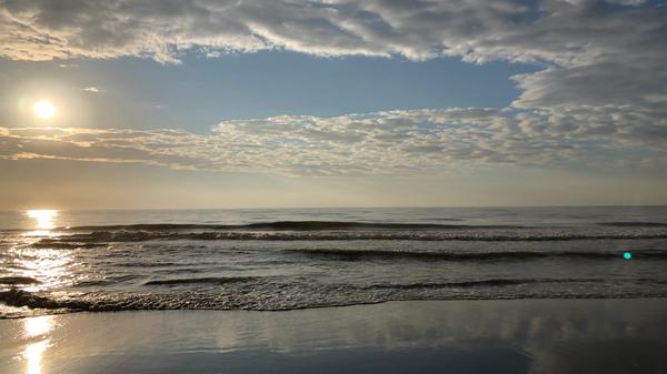 Ocean with sun above and small waves