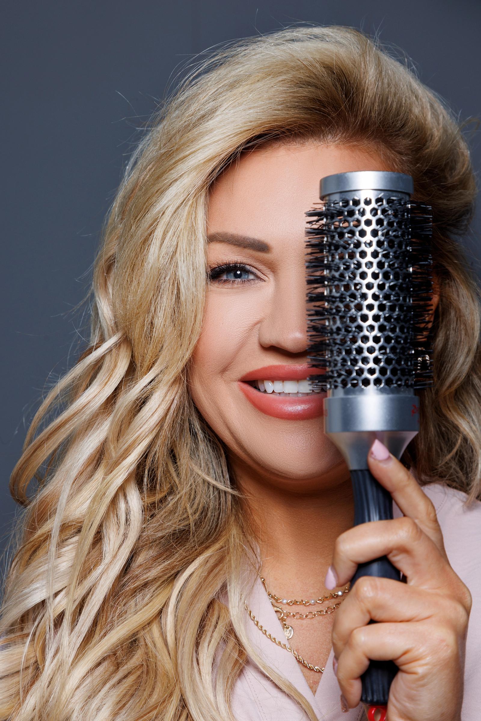 blonde woman holding hairbrush