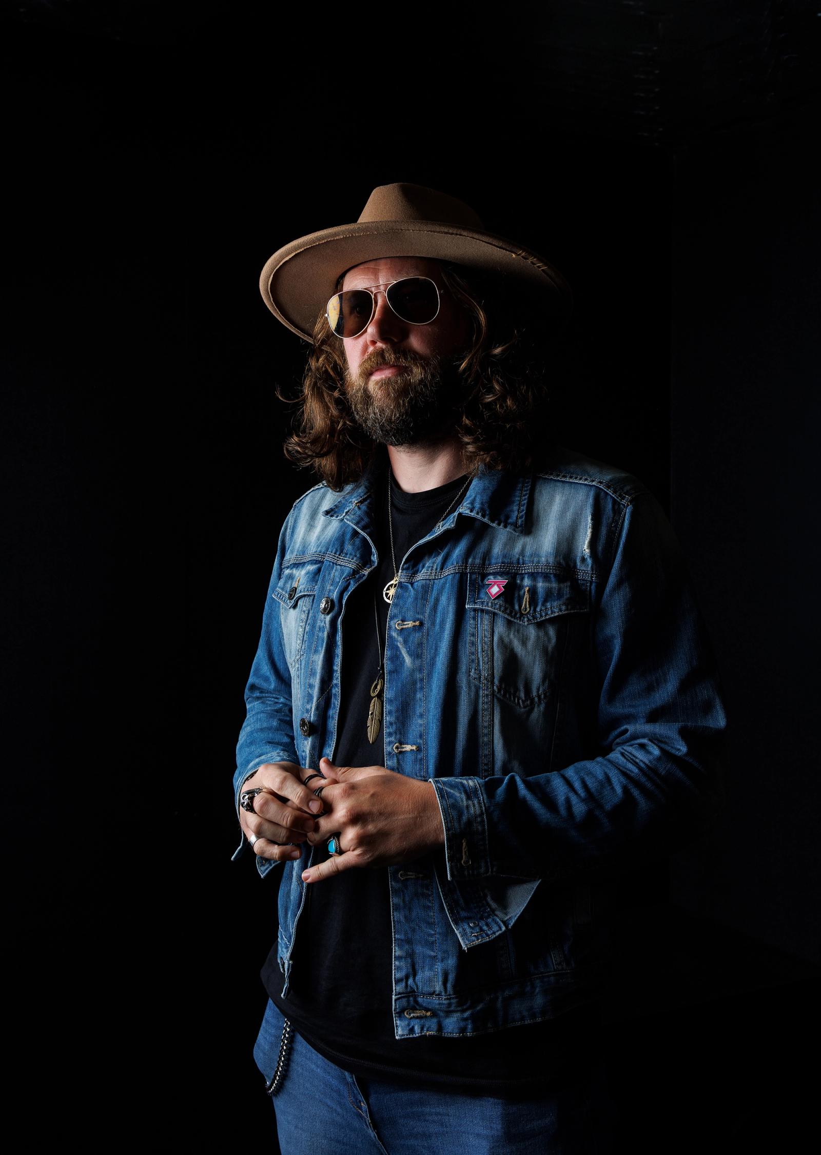 man in denim wearing hat and sunglasses