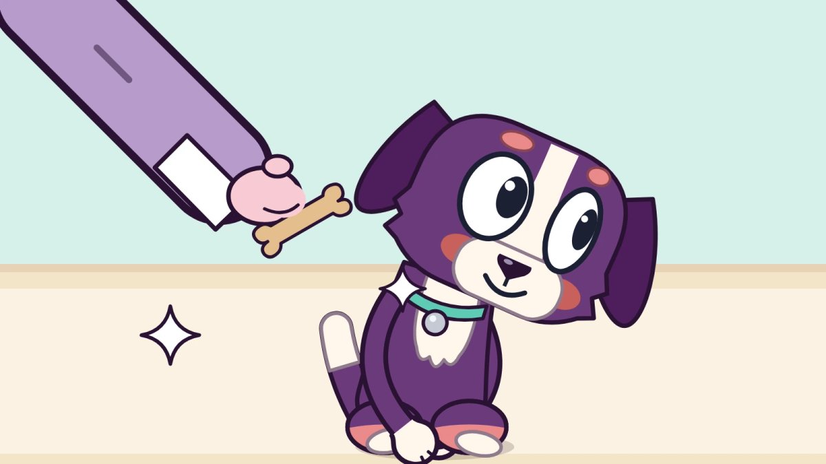 A curious purple pup sits and looks up at a hand in a blue sleeve holding out a small treat.
