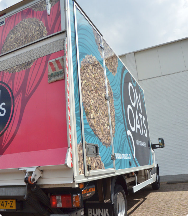 Vrachtwagen met kleurrijke On Oats-bestickering
