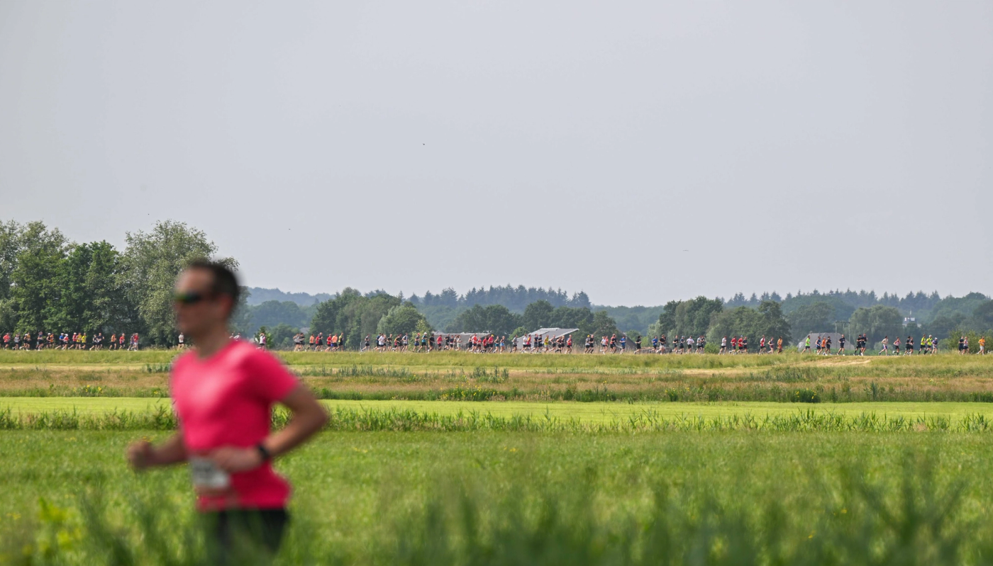 Groep hardlopers bij een historische stadspoort