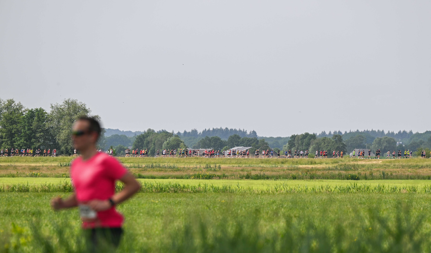 Groep hardlopers bij een historische stadspoort