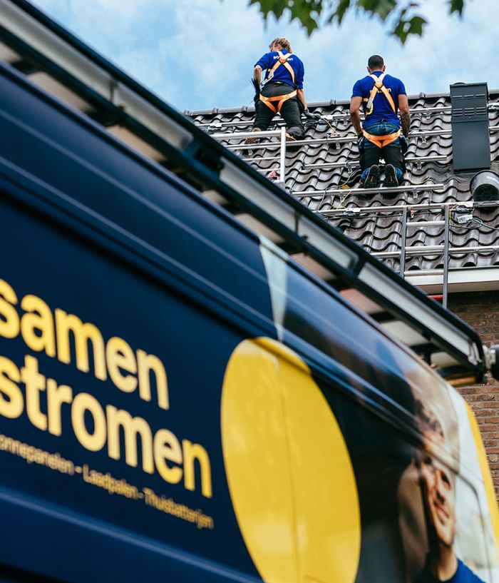 SamenStromen-bestelbus met monteurs op een dak
