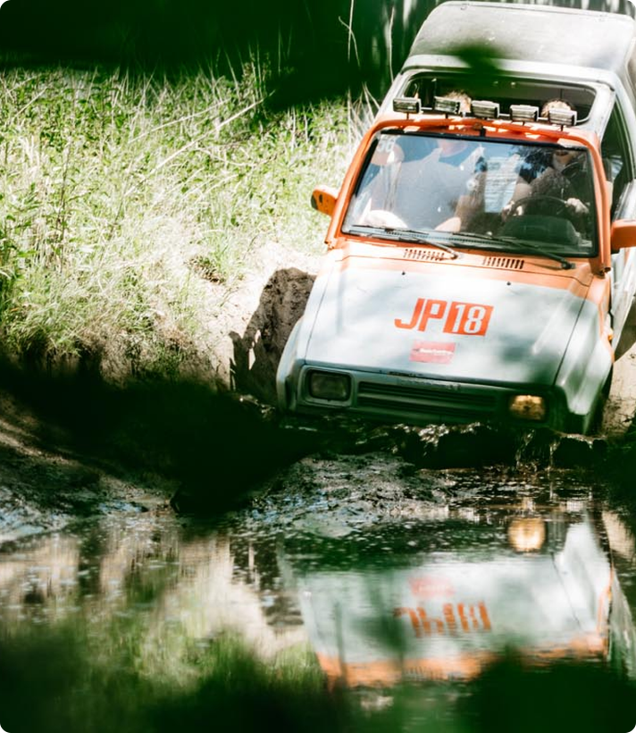Offroad-voertuig ploegt door een modderige waterplas in het bos