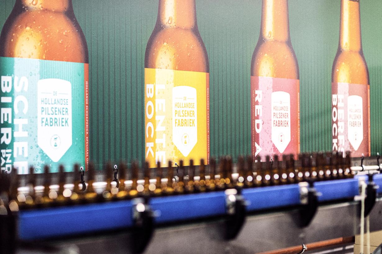 Lopende band met afvullen flesjes van De hollandse Pilsener fabriek