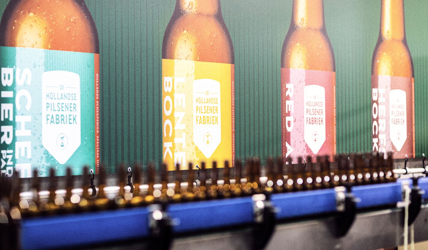 Lopende band met afvullen flesjes van De hollandse Pilsener fabriek