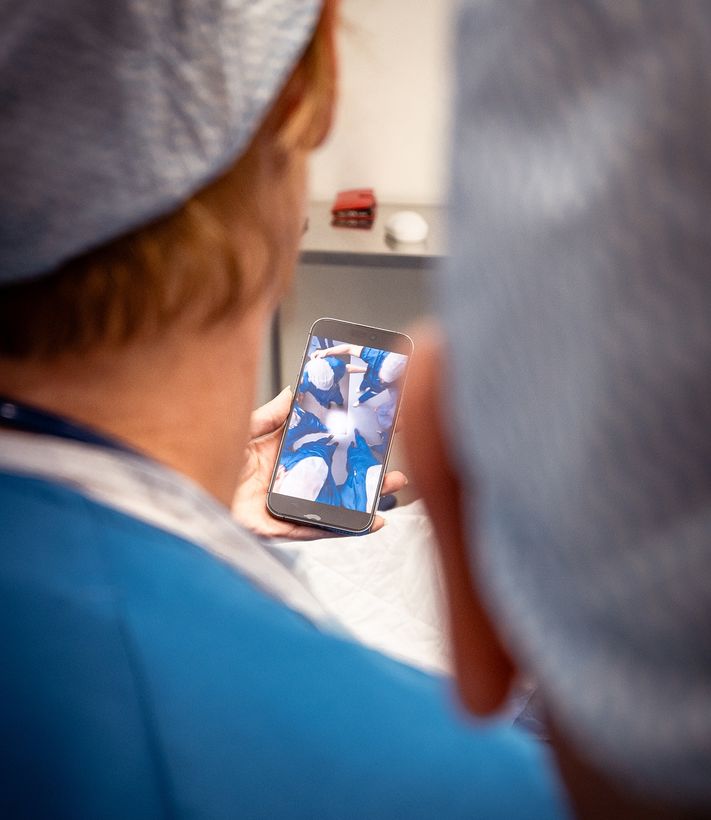Zorgmedewerker bekijkt een video op een smartphone