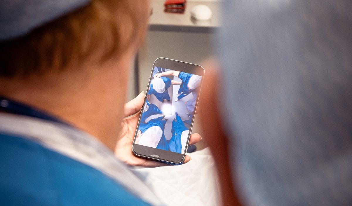 Zorgmedewerker bekijkt een video op een smartphone