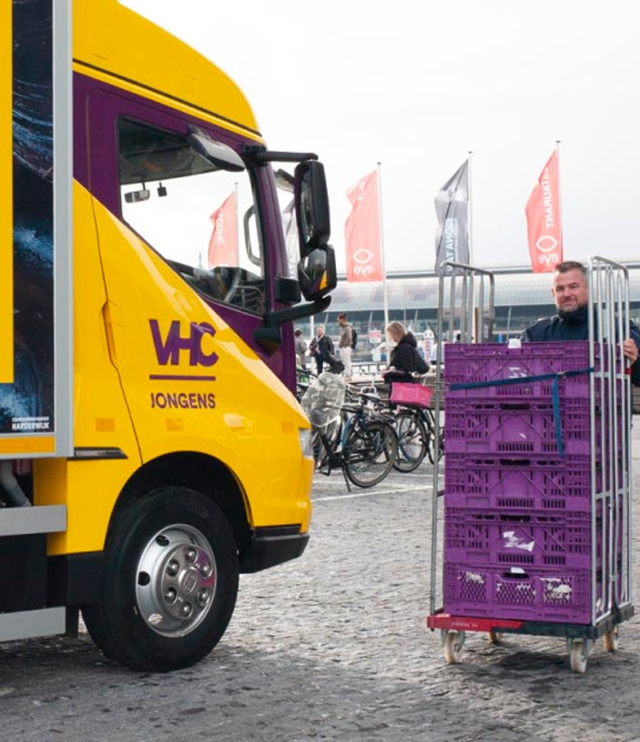 VHC-vrachtwagen naast stapels kratten