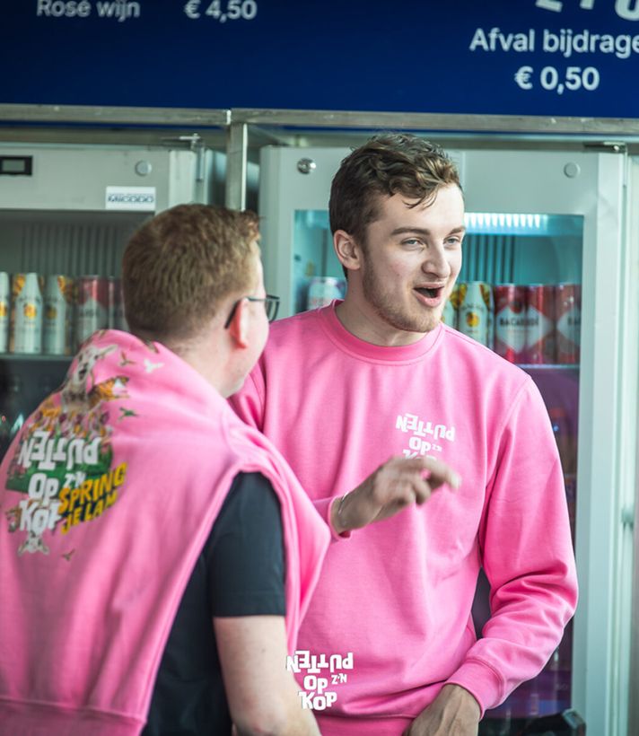 Twee mannen in roze hoodies in het openbaar vervoer