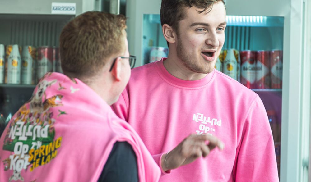 Twee mannen in roze hoodies in het openbaar vervoer