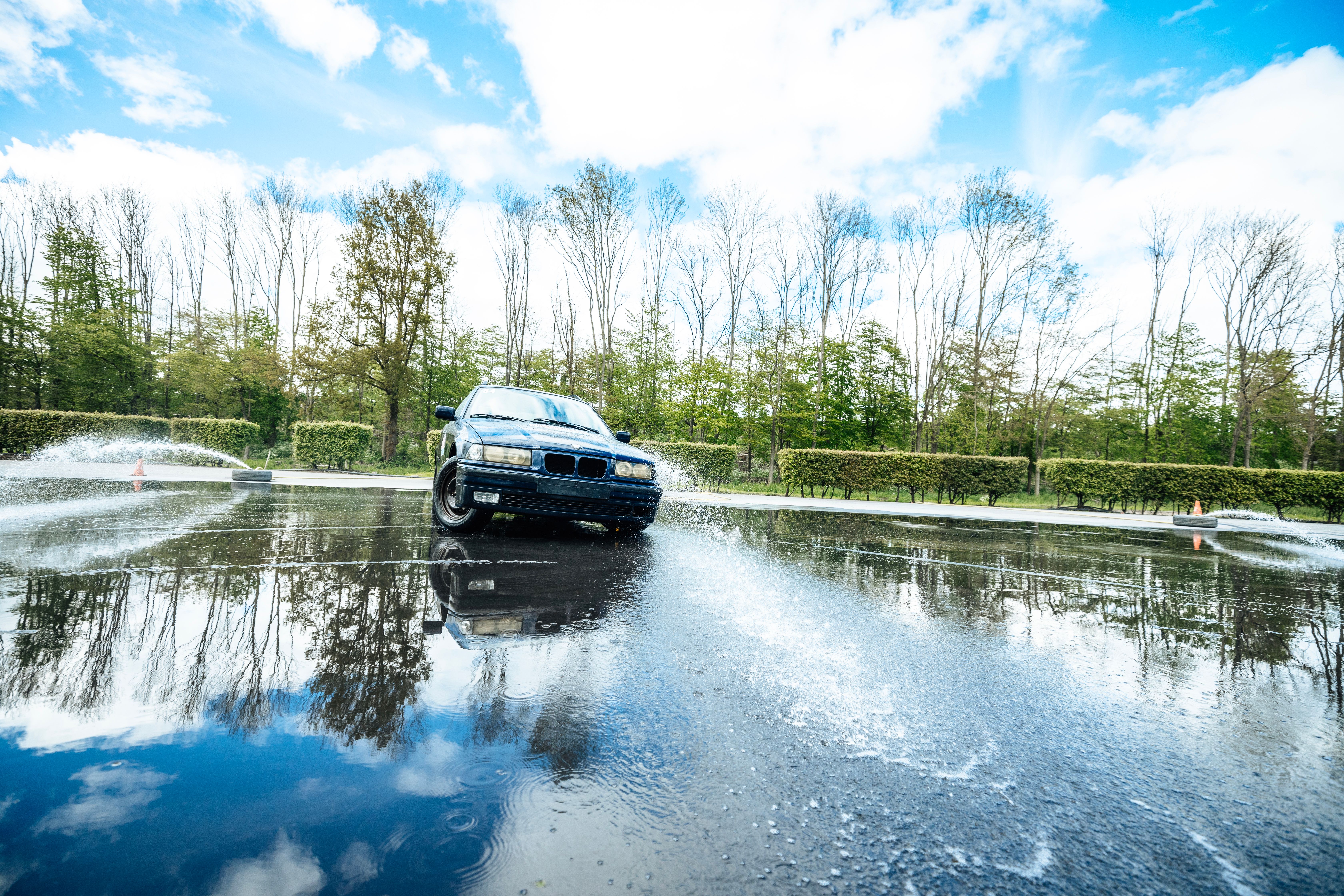 Deelnemer springt met een quad over een houten schans in het bos