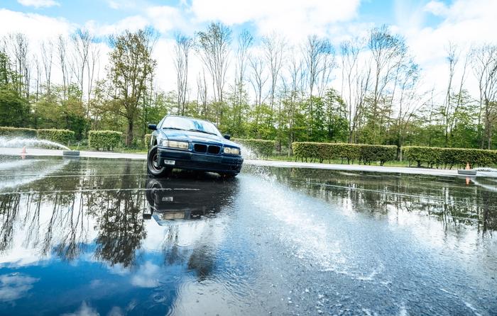 Deelnemer springt met een quad over een houten schans in het bos
