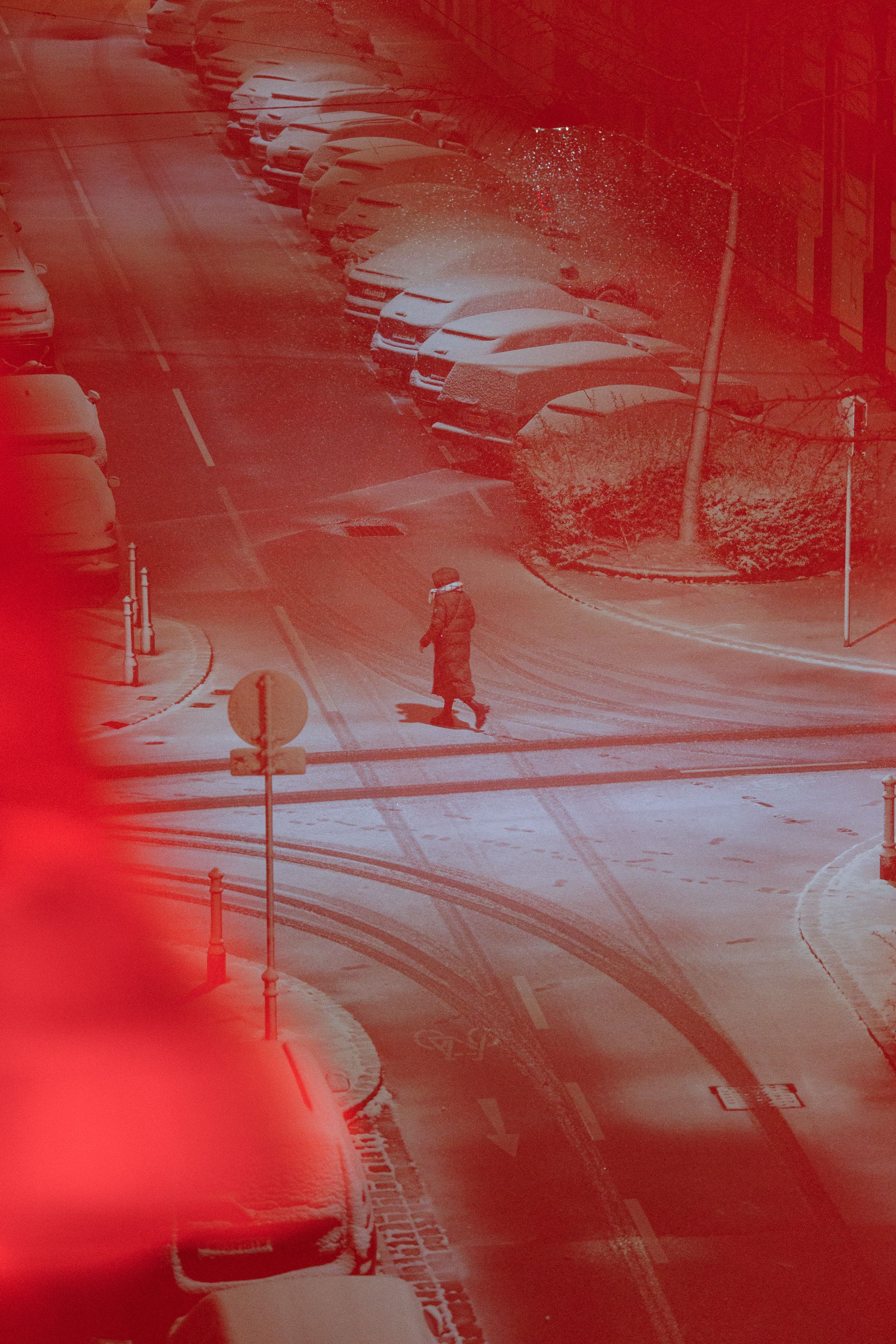 person walking through a snowy urban road everything is red