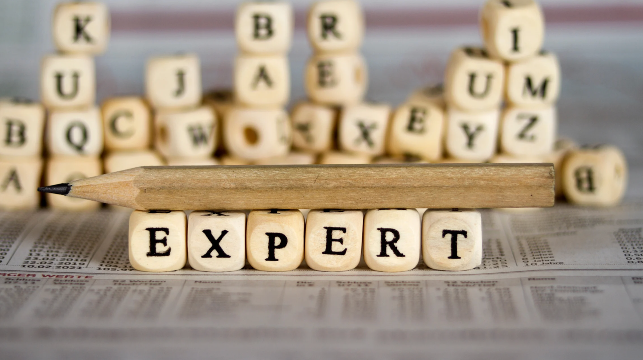 Drewniane kostki z literami układające napis EXPERT