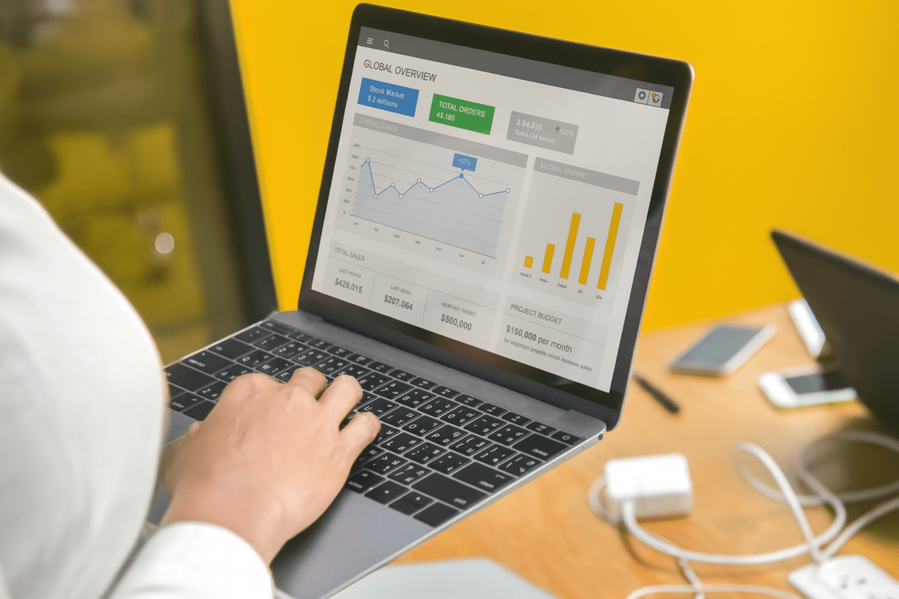 Osoba analizująca wykresy kampanii na laptopie