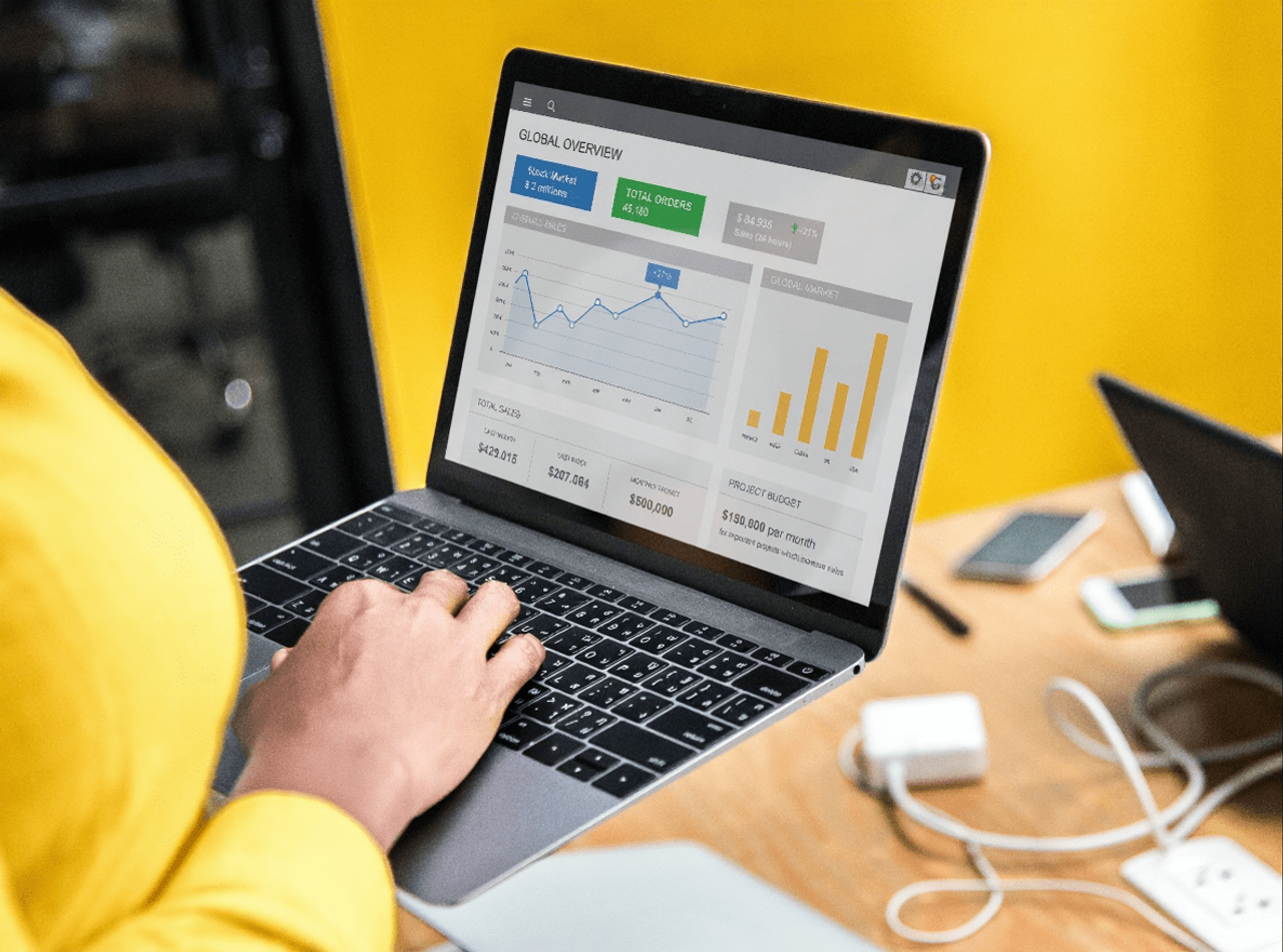 Osoba analizująca wykresy i statystyki na laptopie