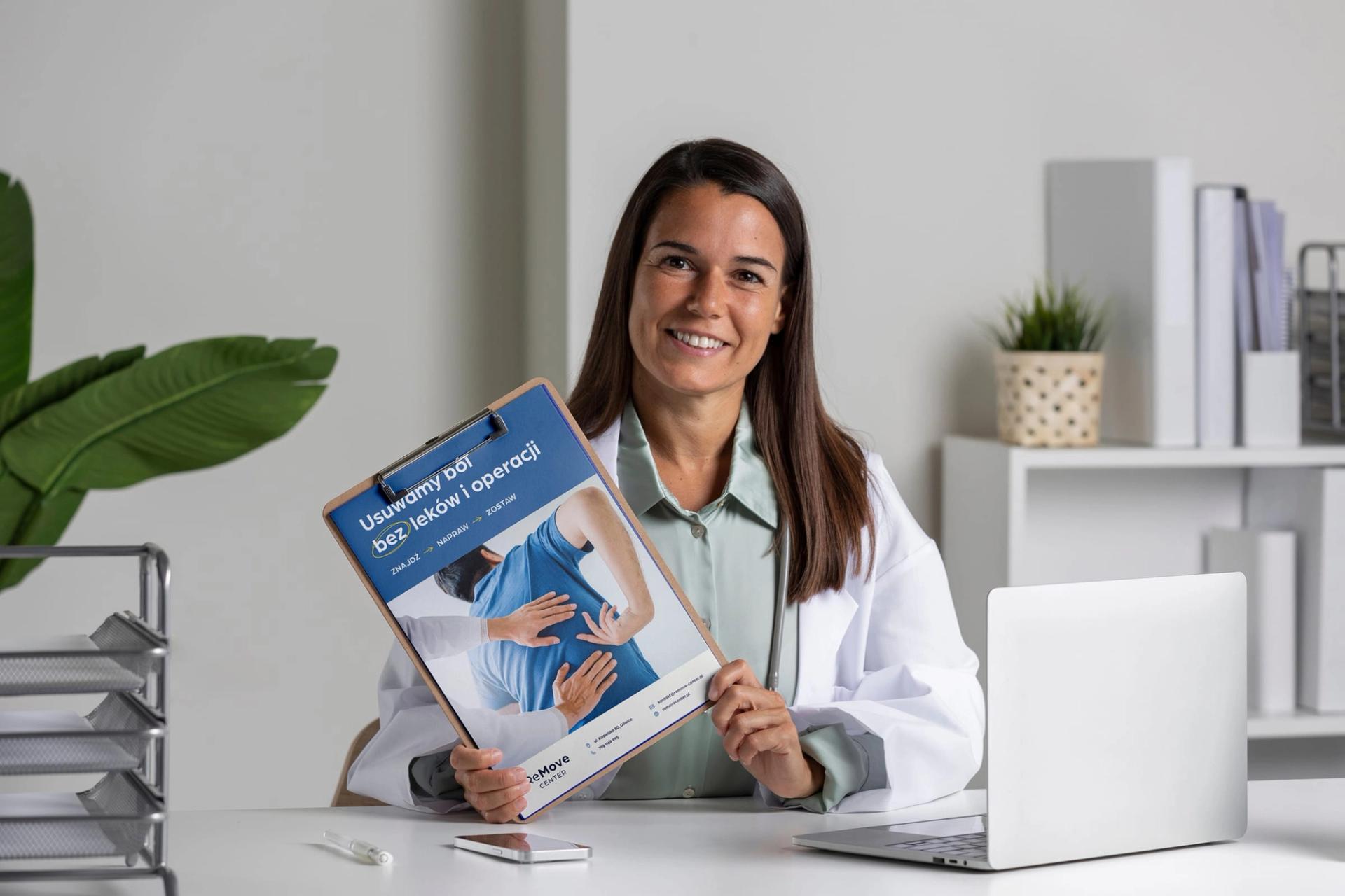 Lekarka ReMove Center prezentująca broszurę z hasłem „Usuwamy ból bez leków i operacji"