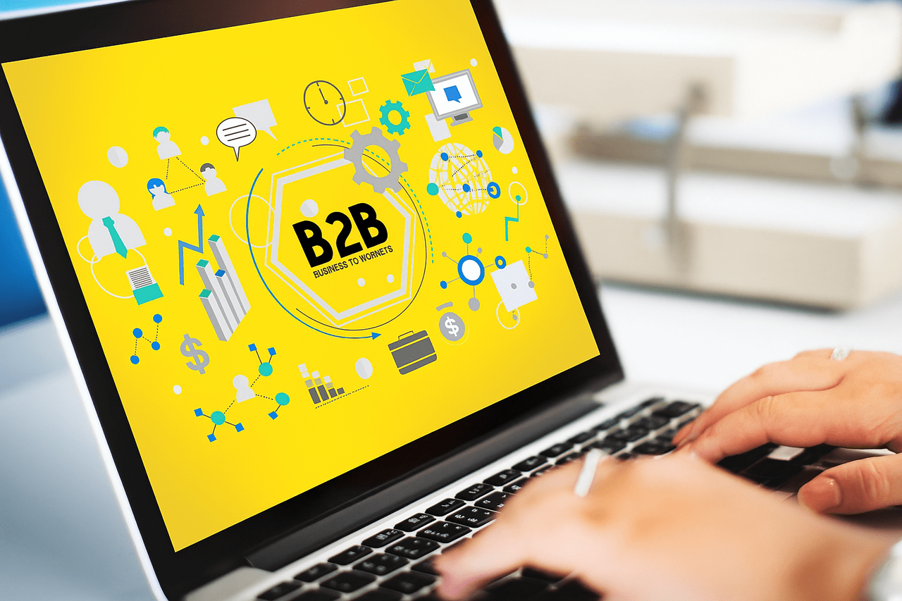 Laptop z grafiką B2B i ikonami marketingowymi na ekranie
