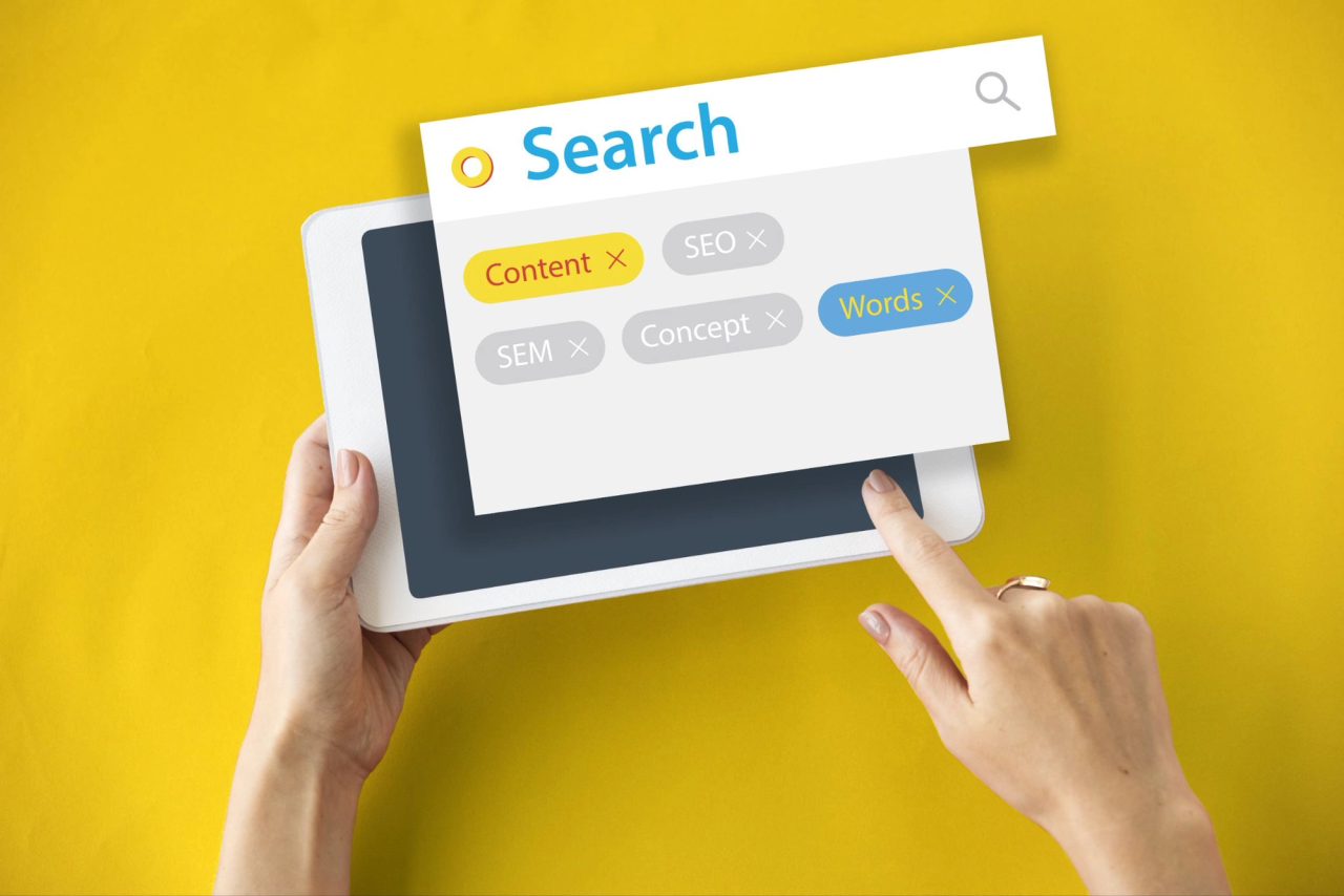 Ręce trzymające tablet z oknem wyszukiwania i tagami Content, SEO, SEM
