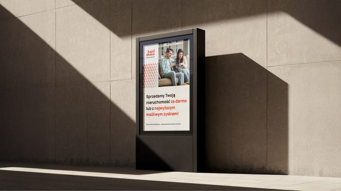 Pionowy bilbord reklamowy Handshake na tle betonowej ściany