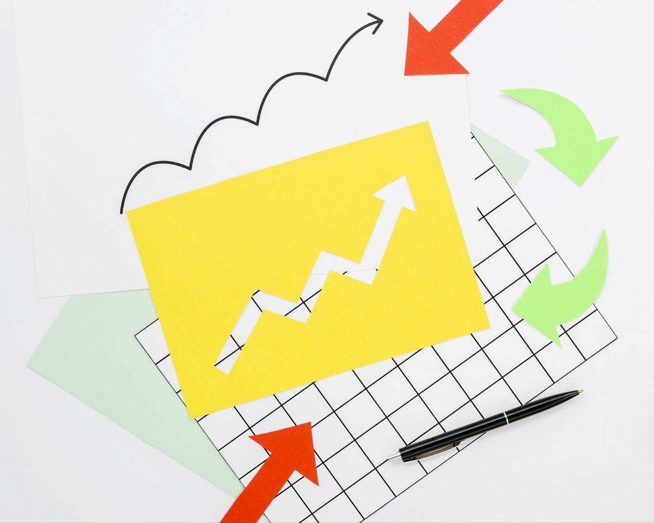 Żółta kartka z białą strzałką wzrostu na kratce obok kolorowych strzałek