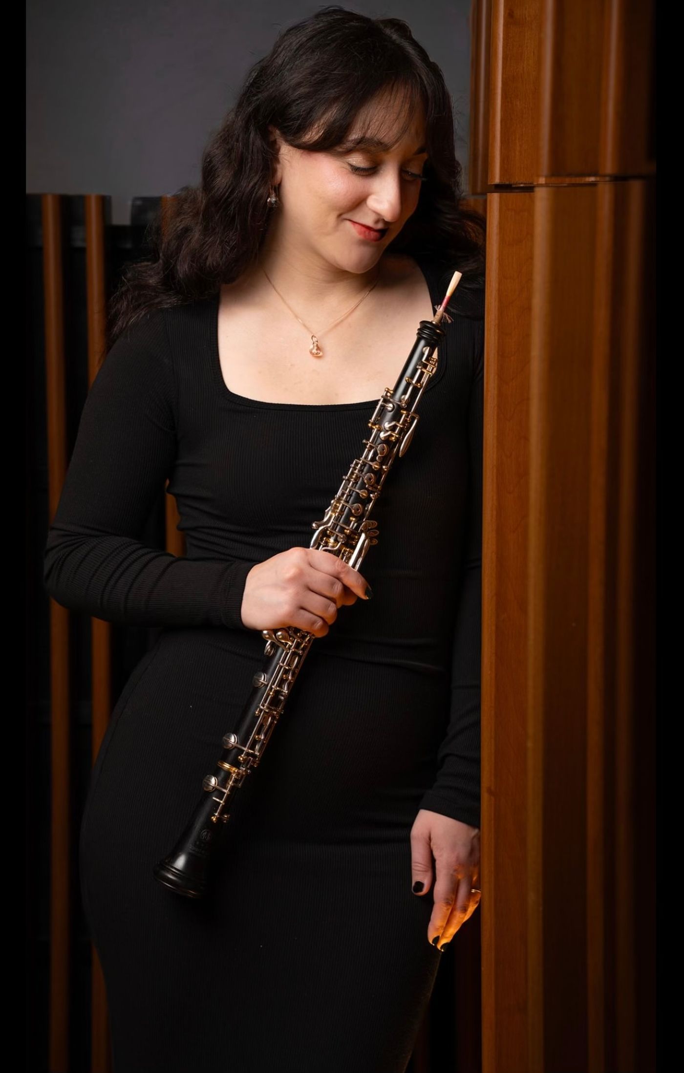 Alexis Porcaro in a black dress, holding her oboe