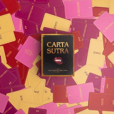 Cartes éparpillées et boite du jeu Carta Sutra au centre