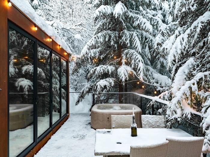 Deck with hot tub, winter evening The Luna cabin deck with hot tub on a winter evening, warm lights among the firs