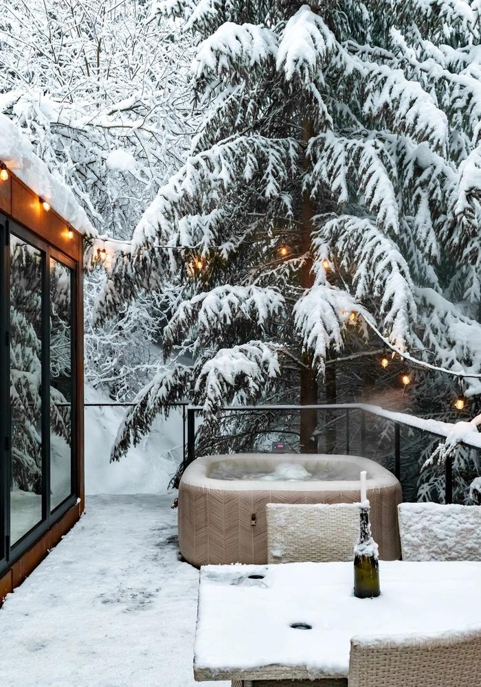 Hot tub terrace in winter The hot tub terrace of the Luna tiny house on a winter evening at Coniferis Retreat