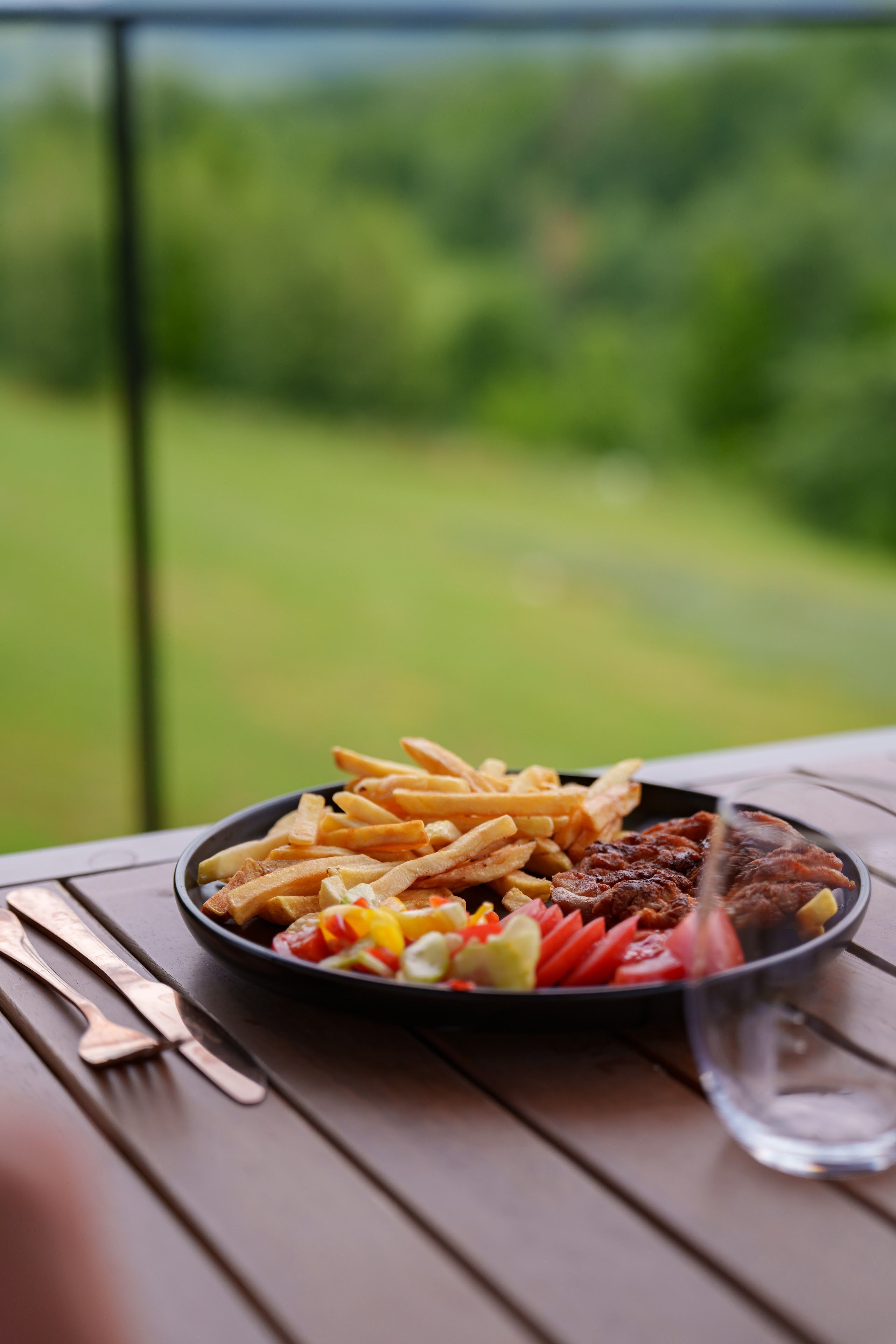 Steak with fries and fresh vegetables, served on the terrace
