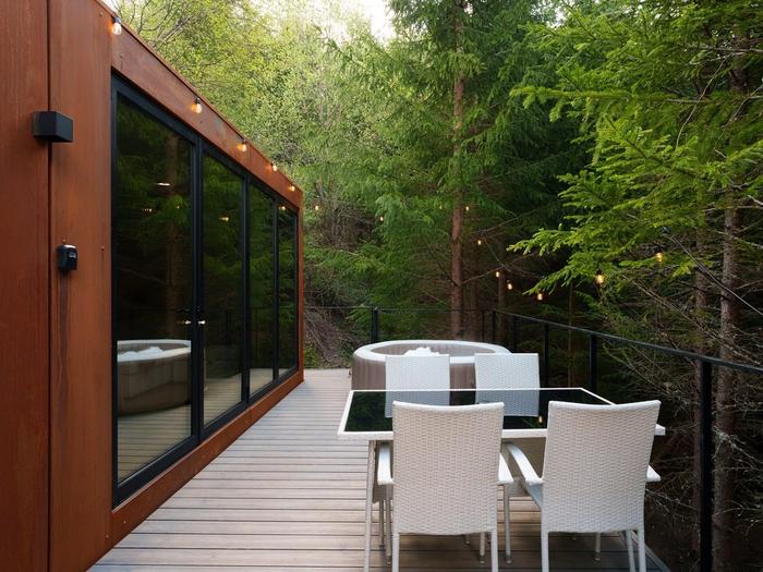 Glass facade and deck The glass facade and long deck of the Luna cabin in summer, deep in the forest