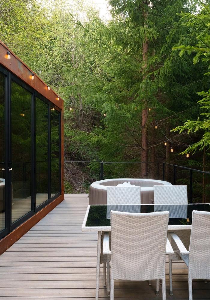 The Luna tiny house in summer The Luna tiny house with glass facade and terrace in summer at Coniferis Retreat