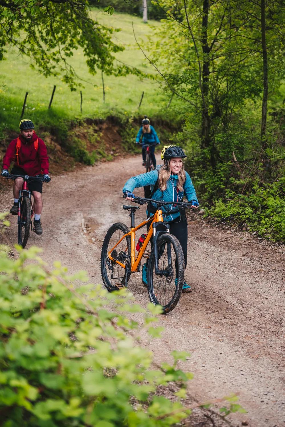A cyclist cornering on a forest road in the Pădurea Craiului Mountains